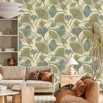 Sage green and beige ginkgo leaf wallpaper in living room with cream sofa and rust armchair