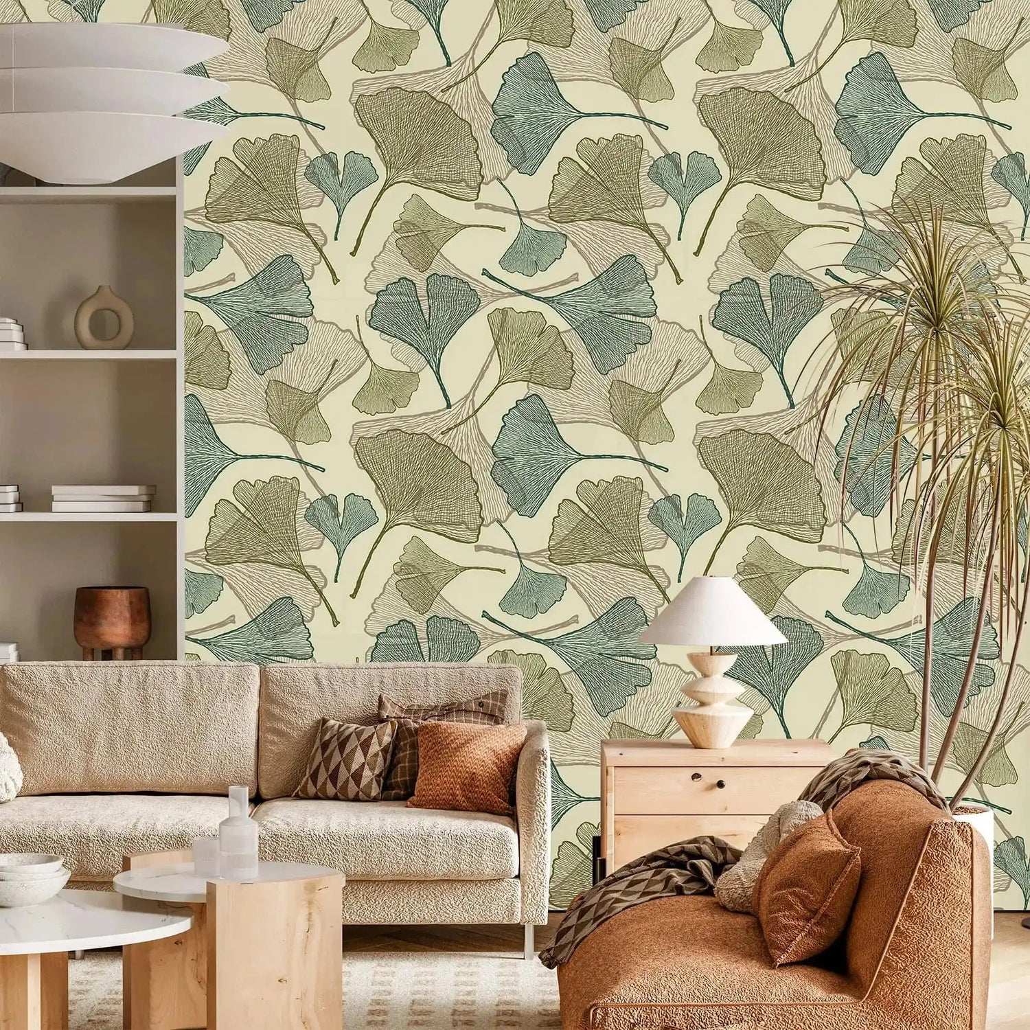 Sage green and beige ginkgo leaf wallpaper in living room with cream sofa and rust armchair