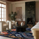 Elegant living room featuring a Sanctuary of Dreams Hand Tufted Area Rug. This vintage wool rug, with its intricate floral and dragon design, adds a touch of luxury under a round dining table. The square area rug complements the modern chairs and black coffee table, making it a perfect choice for dining rooms or living rooms.
