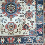 Close-up detail of the Sand and Sea Hand Knotted Area Rug, featuring an intricate floral design with vibrant colors. This vintage Persian-style rug is perfect for large living rooms, adding a touch of elegance and charm to any space.