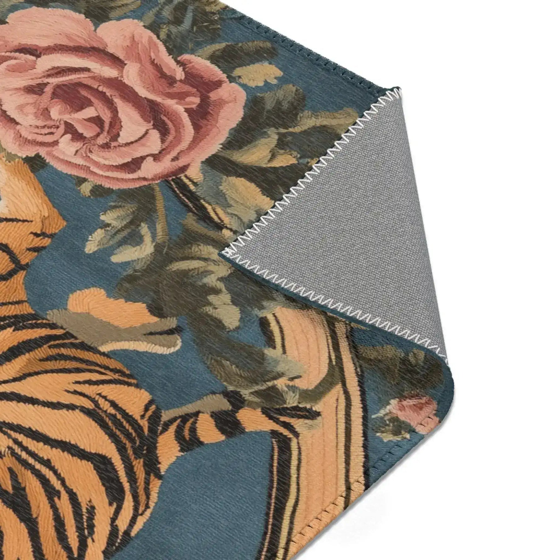 Folded corner showing large pink rose and green foliage with golden tiger body on blue-grey ground on the Savage Symphony Vintage Tapestry of Fierce Elegance