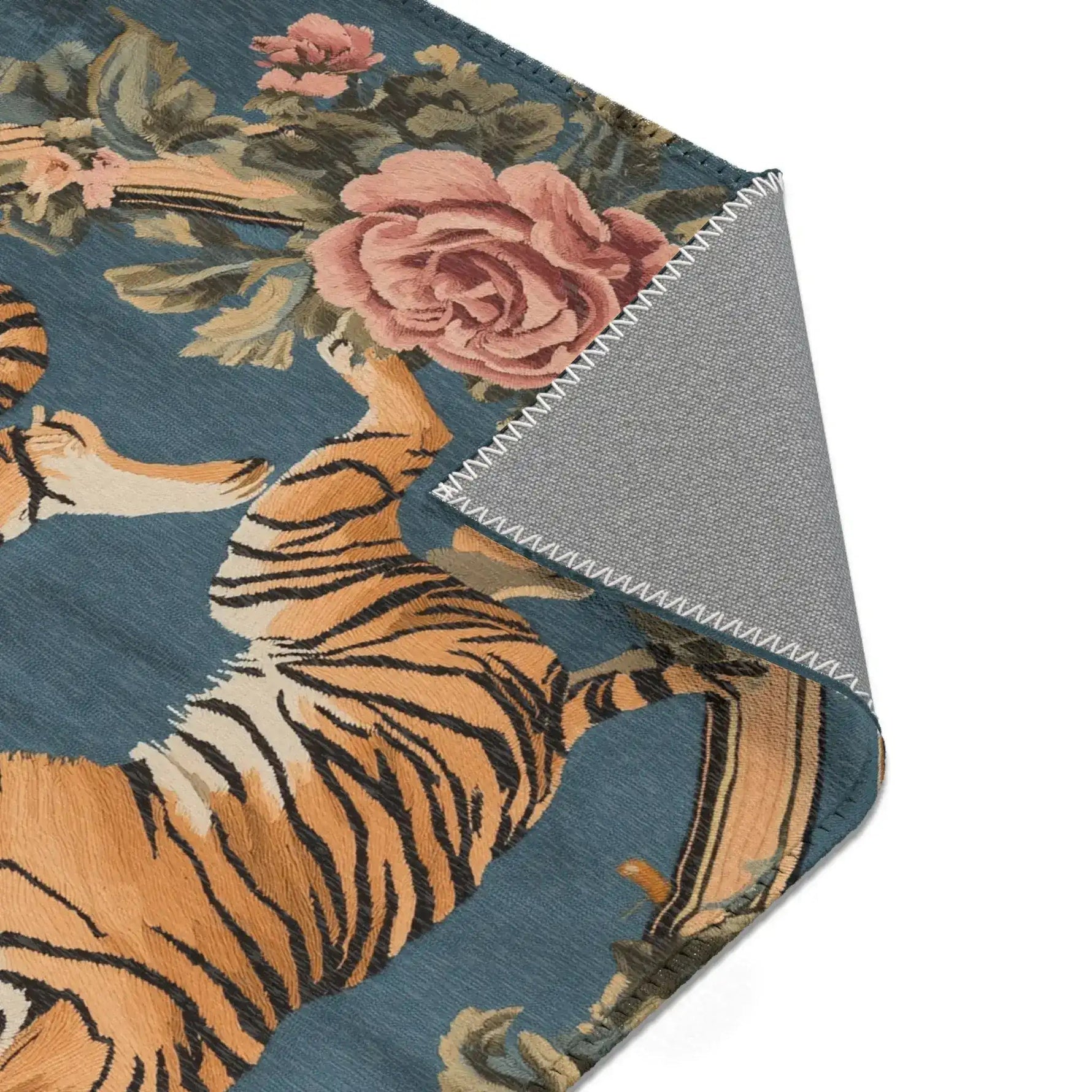 Folded corner showing golden tiger upper body with pink rose and green foliage on blue-grey background on the Savage Symphony Vintage Tapestry of Fierce Elegance