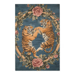 Full view of two golden tigers in combat framed by a rose and leaf floral wreath on dusty blue on the Savage Symphony Vintage Tapestry of Fierce Elegance