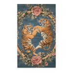 Two rearing golden tigers facing off within an oval wreath of pink roses and green leaves on slate-blue on the Savage Symphony Vintage Tapestry of Fierce Elegance