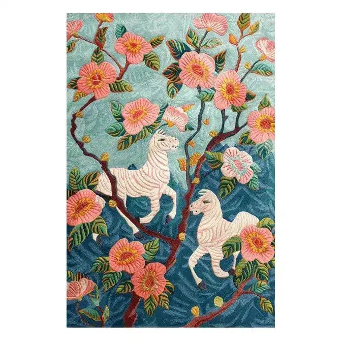 The Savanna Blossom Hand Tufted Rug showcases a vibrant floral design featuring pink blossoms and whimsical white horses against a blue backdrop. This wool area rug is perfect for adding a touch of elegance to a living room. Ideal for those seeking stylish living room rugs in an 8x10 size.