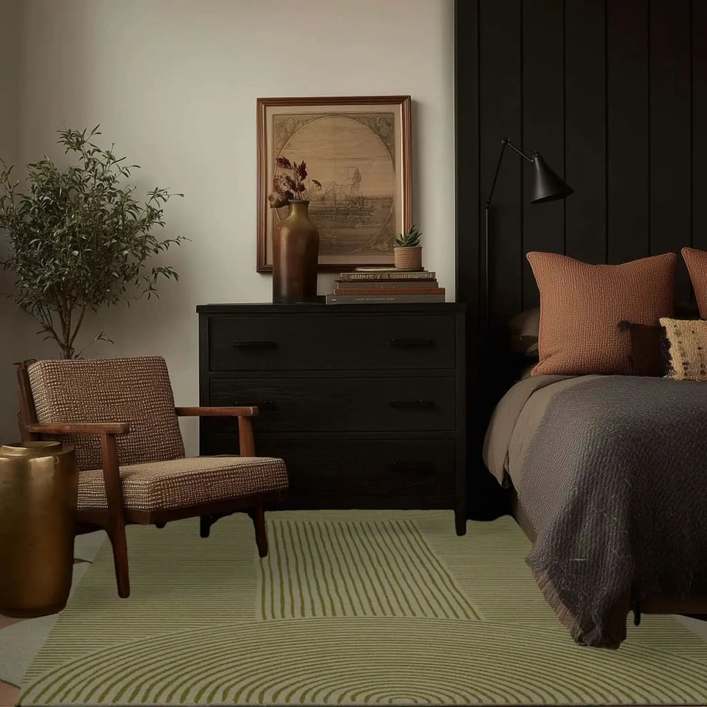 A cozy living room featuring a stylish area rug with a scallop arch geometric design. This wool rug adds a touch of elegance and warmth, perfect for large living rooms. The room is complemented by a dark wooden dresser, textured armchair, and tasteful decor, creating a harmonious and inviting space.