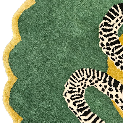 Scalloped green edge and gold border of the snake rug with part of the black-and-white serpent