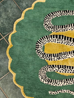 Green rug with a snake design on a tiled floor