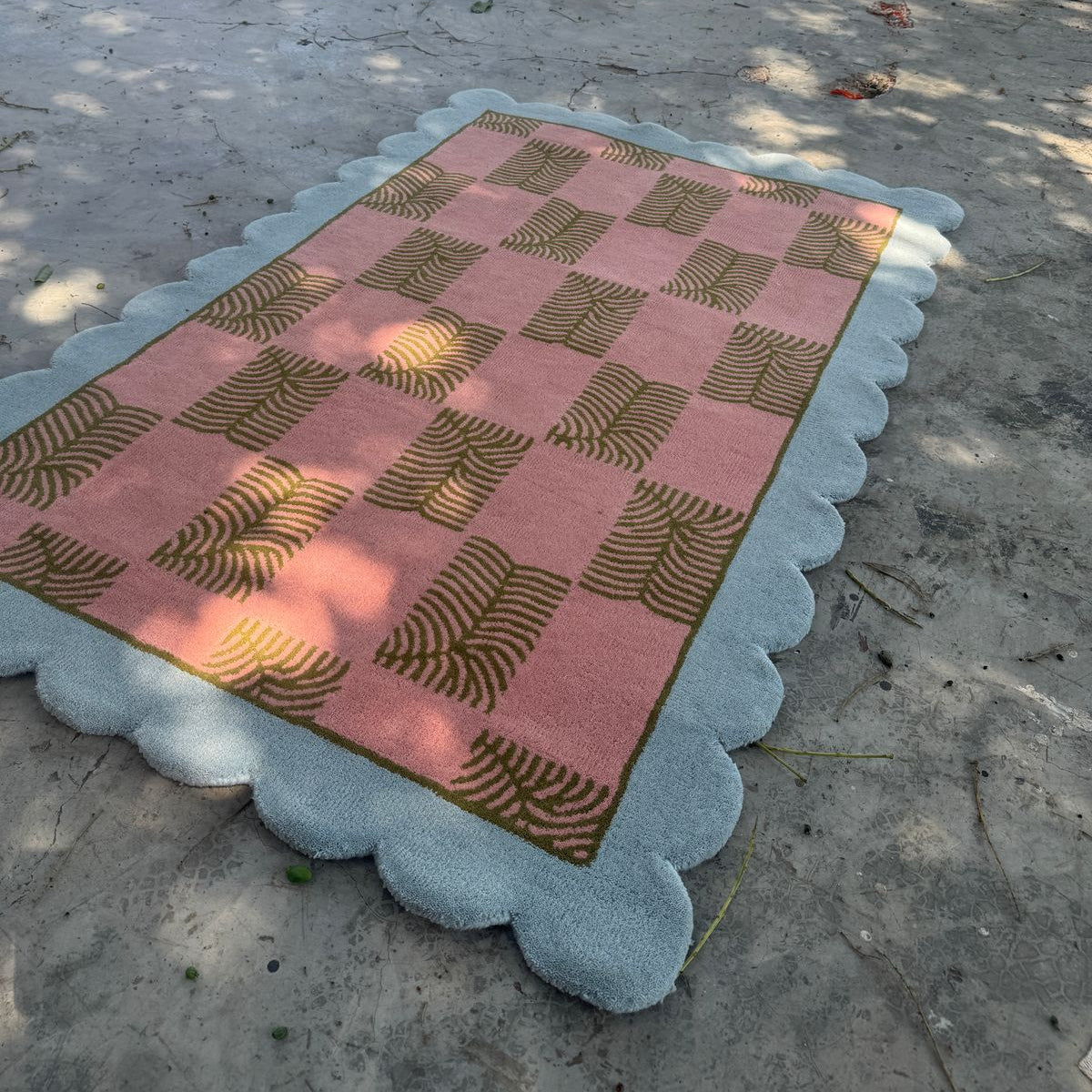Checkered pink and gold rug on a concrete floor