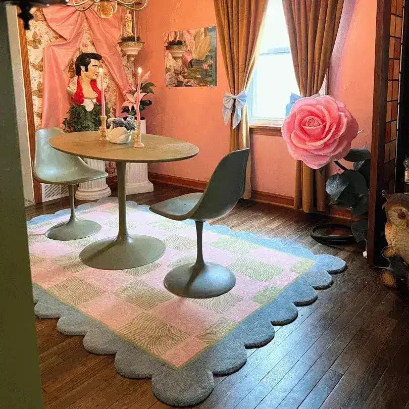 A stylish boho rug with scalloped leaf edges placed in a cozy living room setting. This large area rug, made from wool, features a pastel checker pattern, adding a touch of elegance and warmth to the space. Ideal for large living rooms, the rug complements the mid-century modern furniture and decor.