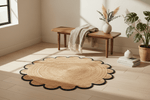 Round jute rug on a wooden floor with a bench and plants in the background