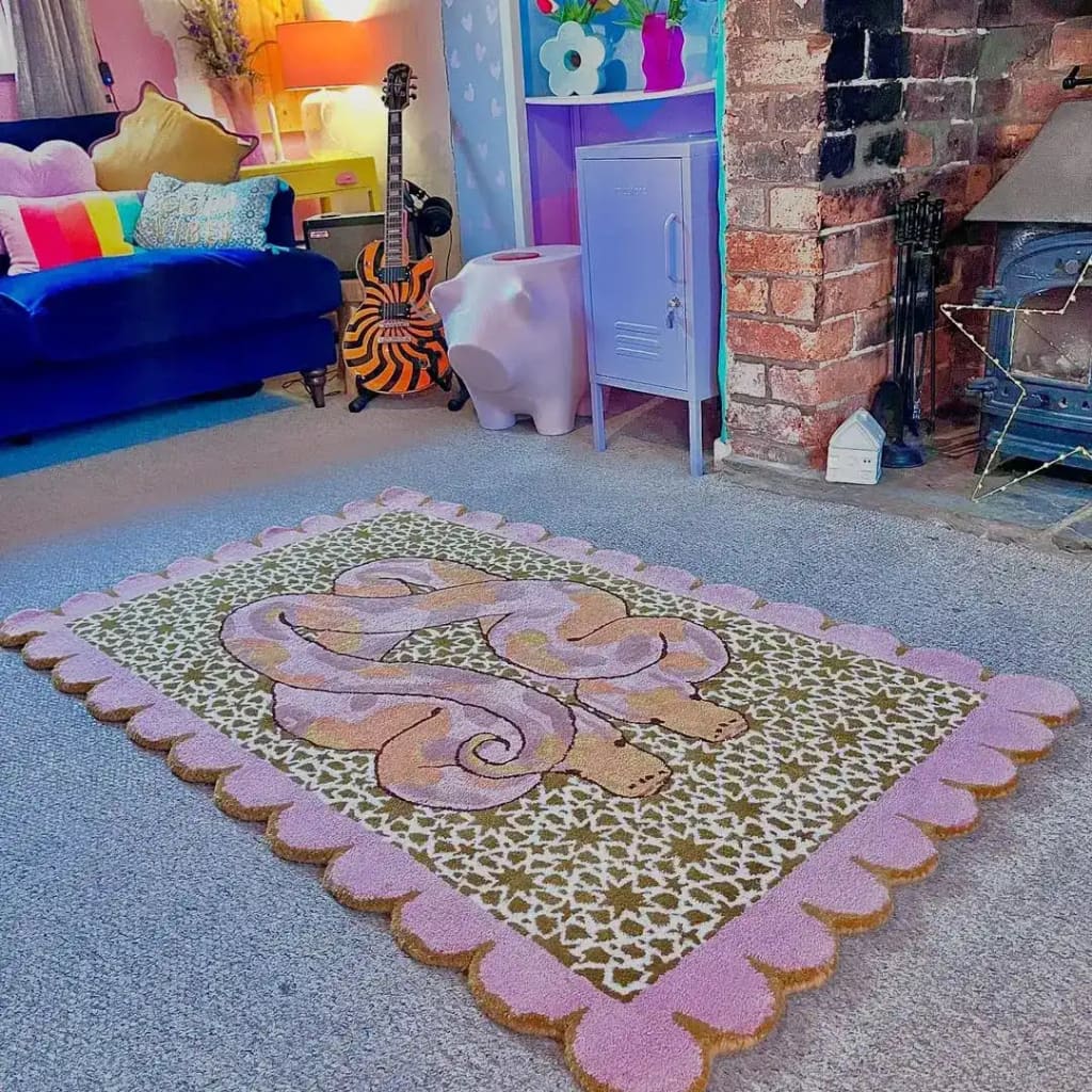 A vibrant and artistic area rug, the Scalloped Serpentine Duo Harmony Hand Tufted Rug, adds a touch of elegance and style to a cozy living room setting. The rug features a playful serpentine design with a scalloped pink border, perfect for enhancing bedroom or living room spaces. Made from quality wool, it's an ideal choice for those seeking unique and colorful bedroom rugs or living room area rugs.