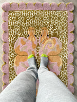 Person wearing socks stepping onto a decorative rug with butterfly design