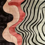 A contemporary area rug featuring a bold, sculptural hand-tufted design with flowing patterns in red, pink, and black tones. Perfect for adding a modern touch to your bedroom or living room, this wool rug combines artistic flair with functionality, making it an ideal choice for bedroom area rugs.