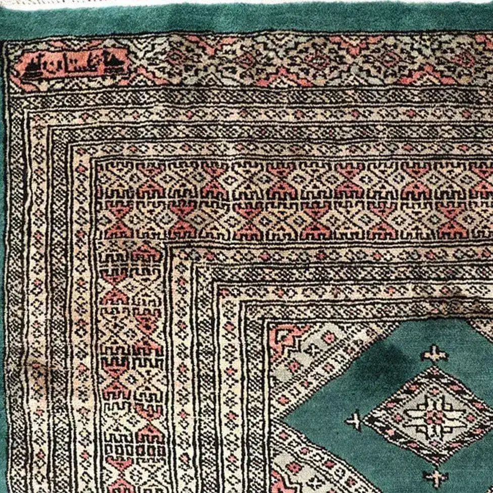 A detailed close-up of a Sea Green Sarong Hand Knotted Area Rug showcasing its intricate geometric patterns and rich colors, perfect for large living room rugs.