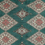 A detailed view of a Sea Green Sarong Hand Knotted Area Rug, featuring intricate geometric patterns in shades of red, white, and black. This elegant large living room rug showcases a series of diamond shapes on a sea green background, perfect for adding a touch of sophistication to any space.