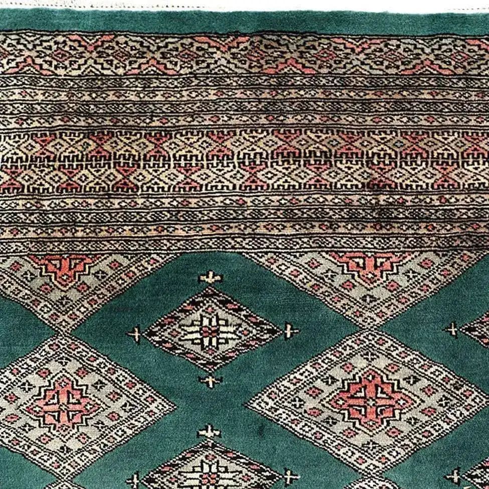 A beautifully detailed Sea Green Sarong Hand Knotted Area Rug featuring intricate geometric patterns in earthy tones. Ideal for large living room rugs, this image showcases the rug's exquisite craftsmanship and vibrant colors from a top-down view.