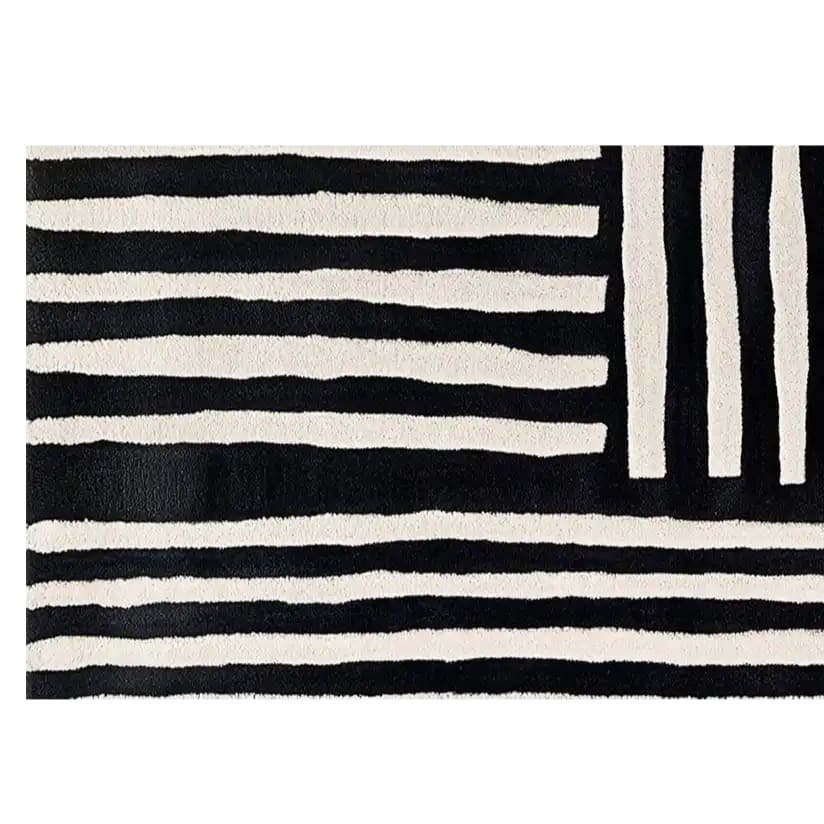A contemporary wool runner rug featuring bold black and white stripes in an abstract pattern. Perfect for adding a modern touch to kitchens, hallways, or bathrooms, this hand-tufted rug combines style and functionality.