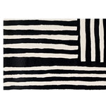 A contemporary wool runner rug featuring bold black and white stripes in an abstract pattern. Perfect for adding a modern touch to kitchens, hallways, or bathrooms, this hand-tufted rug combines style and functionality.