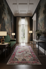 Luxurious living room with classical decor, including a green sofa, patterned rug, and wall art.