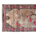 Serenade of Blossoms Knotted Wool Rug featuring a stunning floral design with vibrant pink blossoms on delicate branches. This 8x10 area rug is perfect for adding elegance to living room spaces.