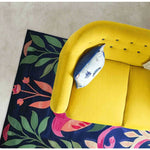 A vibrant area rug with a floral design in rich colors beneath a yellow couch, perfect for adding a pop of color to dining rooms or bedrooms. This wool rug enhances any space with its artistic touch, ideal for dining room carpets or as stylish rugs for the bedroom.