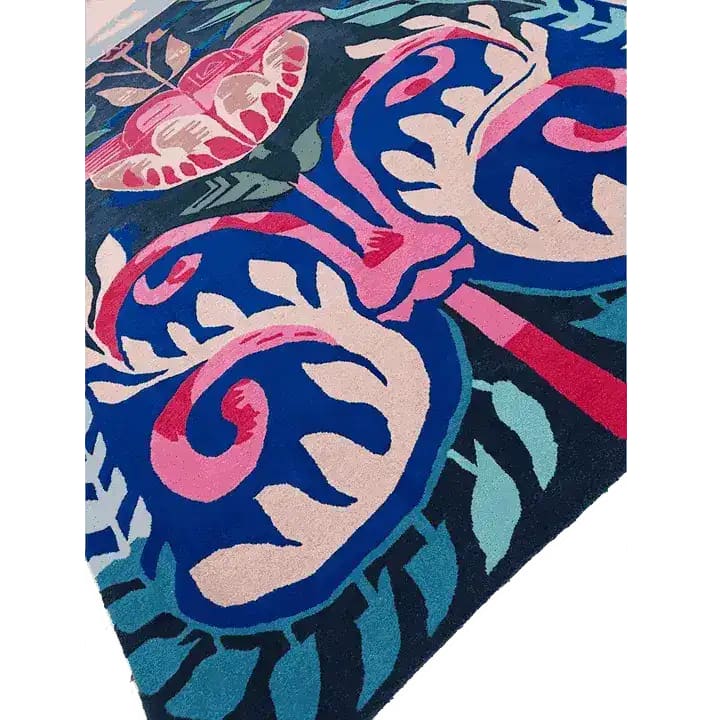 Vibrant Serenade of Mexico Hand Tufted Area Rug featuring bold floral patterns in pink, blue, and green, perfect for enhancing a dining room or bedroom with its artistic design. This wool rug adds a splash of color, making it an ideal choice for those seeking unique dining room carpets or rugs for a bedroom.