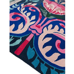 Close-up view of the Serenade of Mexico Hand Tufted Area Rug, showcasing vibrant floral designs in pink, blue, and red, perfect for enhancing the ambiance of a dining room or bedroom. This wool rug adds a touch of elegance and warmth, ideal for those seeking floral rugs or dining room carpets.