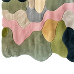 A vibrant and artistic area rug featuring a blend of pastel colors in an abstract pattern, perfect for enhancing any living room space. This hand-tufted wool rug showcases shades of pink, green, yellow, and gray, adding a touch of elegance and warmth. Ideal for those seeking stylish living room rugs 8x10.