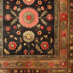 The Serene Sanctuary Hand Knotted Area Rug showcases an intricate floral design with vibrant pink and yellow blossoms against a dark backdrop, reminiscent of a vintage Persian rug. Perfect for large living room spaces, this floral rug adds a touch of elegance and timeless charm to any setting.