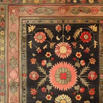 A stunning, vintage-inspired Serene Sanctuary Hand Knotted Area Rug featuring a detailed floral design. This large living room rug showcases vibrant hues on a dark background, reminiscent of traditional Persian rugs. Ideal for adding a touch of elegance to any space, this floral rug is perfect for those seeking unique rugs for living rooms.