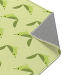Serene songbird rug corner folded up, green birds on celery green with gray non-slip backing