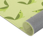 Serene songbird rug rolled at corner, close green bird motifs and gray backing on celery ground