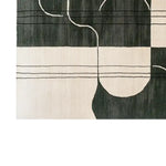 Close-up view of the Serene Soul Labyrinth Knotted Wool Rug showcasing its contemporary abstract design with black and white lines. This area rug is perfect for modern living rooms, available in an 8x10 size, crafted from high-quality wool.