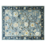 Top view of a Serenity Garden hand tufted wool area rug, featuring intricate floral patterns in soft blues and creams. Perfect for large living room spaces, this elegant wool rug adds a touch of nature-inspired design.