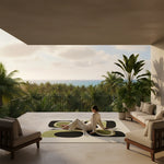 Person sitting on a modern patio with an abstract wool rug, ocean view and palm trees