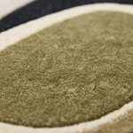 Serenity Shapes Hand Tufted Rug close-up of olive green oval shape with cream border and black outer band, wool texture detail