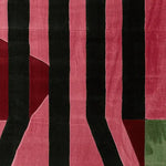 Top view of the Shadow Line Fold Hand Tufted Area Rug featuring bold black and pink stripes with red and green accents. This contemporary wool rug is perfect for adding a modern touch to your living room decor.