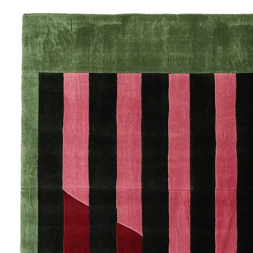 Top view of a Shadow Line Fold Hand Tufted Area Rug, showcasing its contemporary design with alternating pink and black stripes bordered by a lush green. This wool rug is perfect for adding a modern touch to living room spaces, ideal as a living room area rug.