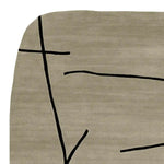 A contemporary area rug featuring a hand-tufted design with abstract black lines on a beige wool background. Perfect for adding a modern touch to living rooms.
