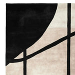 A close-up view of the Shadow Thread Geometry hand-tufted area rug, showcasing its contemporary design. The wool rug features bold black geometric patterns against a soft beige background, perfect for modern living room area rugs.