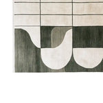 The Shadowed Abyss Grace Knotted Wool Rug features an abstract geometric pattern in shades of black and white. This contemporary area rug, made from high-quality wool, is ideal for modern living rooms, adding a touch of elegance and sophistication.