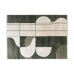 A stylish area rug named 'Shadowed Abyss Grace Knotted Wool Rug' showcasing a contemporary abstract design with bold geometric patterns in dark and light shades. This wool rug adds a modern touch, perfect for enhancing the aesthetics of living rooms.