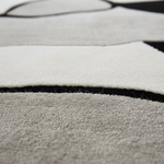 Close-up of a textured rug with black lines on a gray background