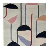 A stylish area rug featuring an abstract design with bold, colorful shapes and lines, perfect for adding a contemporary touch to any living room. This hand-tufted wool rug combines dark and pastel colors on a neutral background, making it an ideal large living room rug.