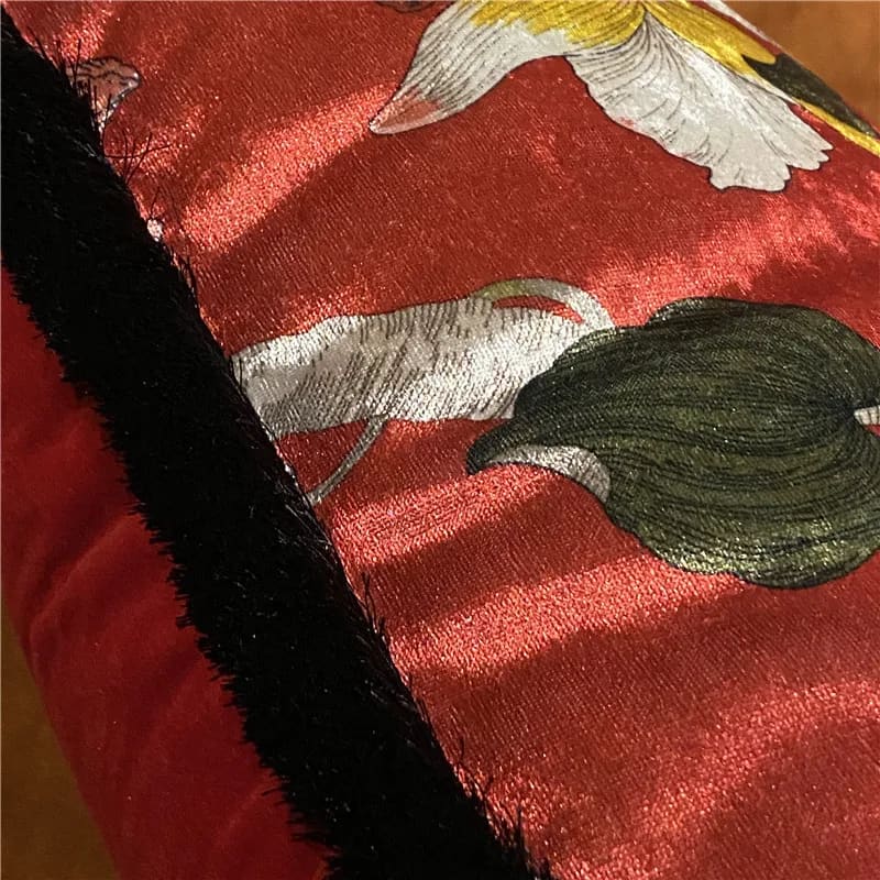 Shiny velvet throw pillow cover in scarlet red with intricate floral designs and a plush black trim, perfect for adding a touch of elegance to your home decor.