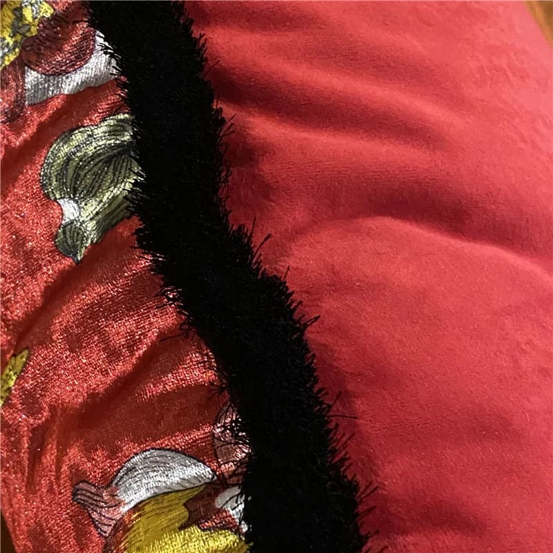 Shiny velvet scarlet throw pillow cover with vibrant floral embroidery and textured black trim, perfect for adding a pop of color to any decor.