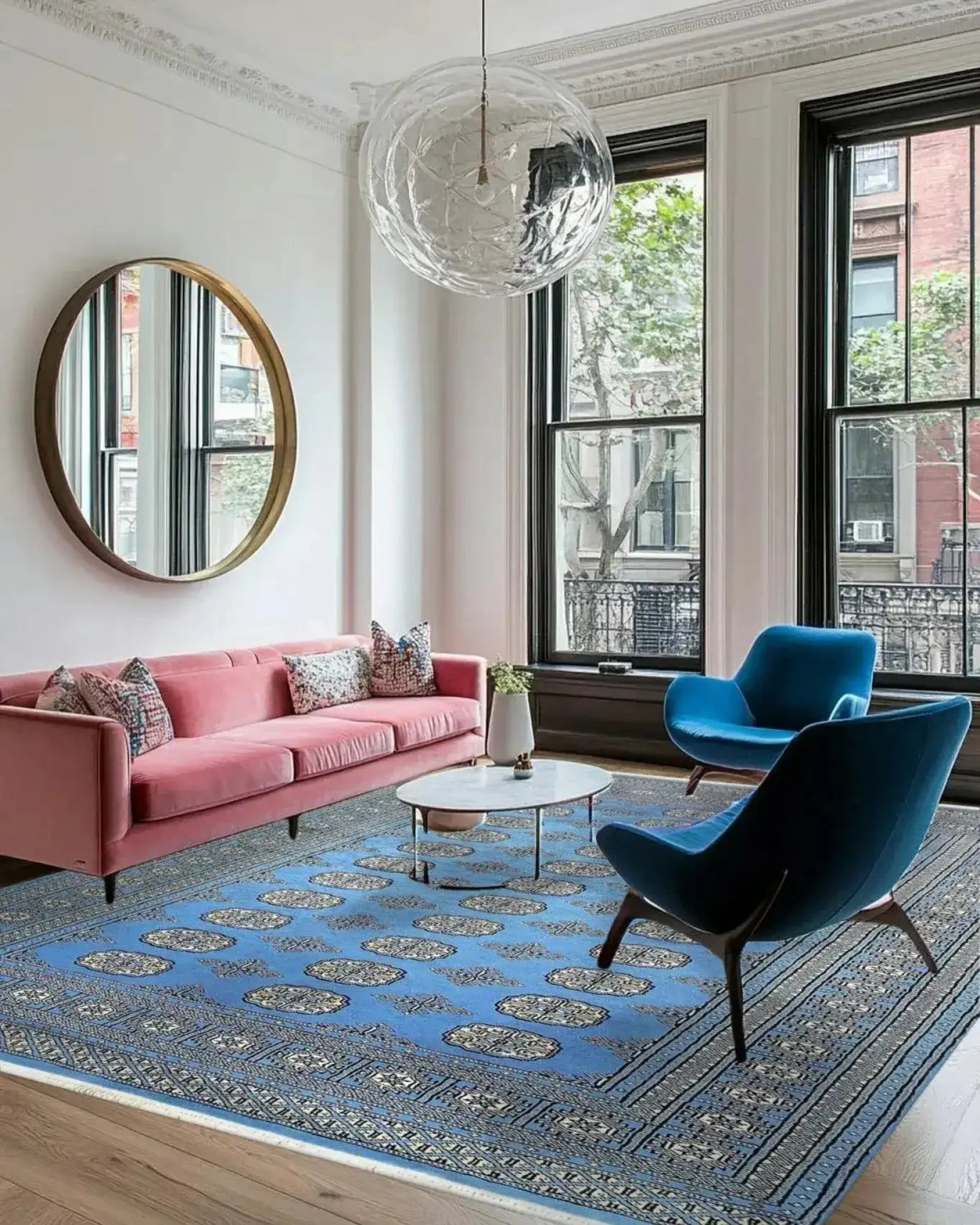 A stylish living room featuring a Sky Blue Anirudha Hand Knotted Area Rug. This elegant rug complements the modern decor with its intricate patterns, enhancing the living room area. The soft blue tones of the rug add a touch of sophistication, making it a perfect choice for those seeking rugs for living room spaces.