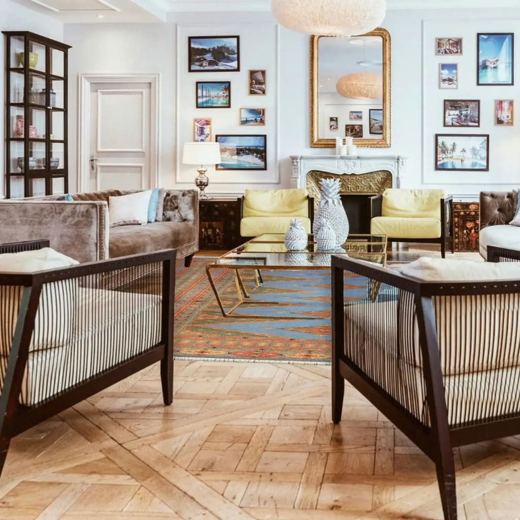 A stylish living room featuring the Sky Blue Java Kingdom Hand Knotted Area Rug, perfect for adding a touch of elegance to any space. This large living room rug showcases an intricate design with vibrant colors, complementing the modern furniture and art-filled walls.