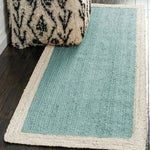 Sky blue rectangular jute area rug with a textured pattern, perfect for a boho vibe in large living rooms. The rug complements dark wooden floors and is paired with a patterned cushion, showcasing its versatility as a large area rug.